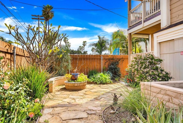 view of patio featuring a fenced backyard and a balcony