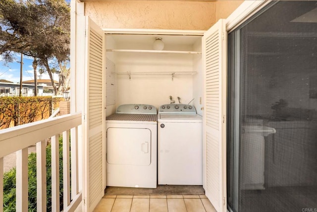 laundry area with washing machine and clothes dryer, laundry area, and light tile patterned floors