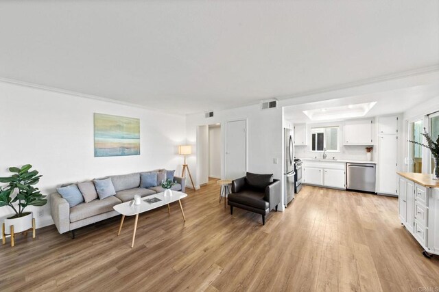 1118 S Pacific St Unit B, Oceanside, CA 92054 - living area with light wood-style flooring and crown molding