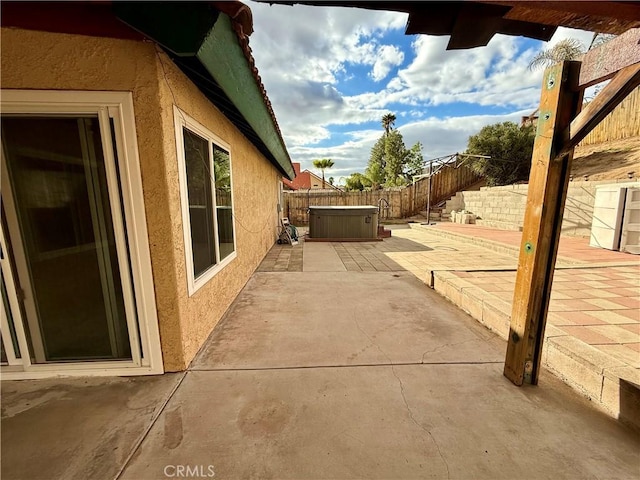 view of patio / terrace featuring a hot tub and a fenced backyard