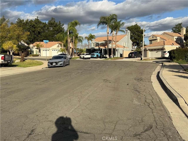 view of street with street lights, sidewalks, and a residential view