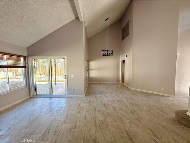 unfurnished room featuring high vaulted ceiling, baseboards, light wood-style flooring, and a textured ceiling