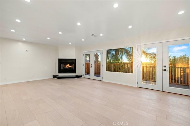 unfurnished living room with light wood-type flooring, recessed lighting, french doors, and visible vents