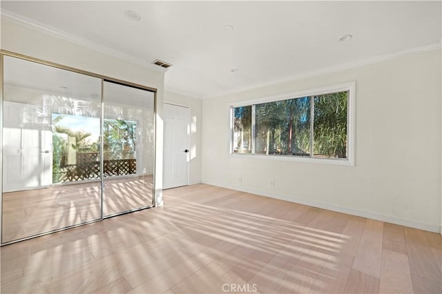 unfurnished room with baseboards, visible vents, and crown molding