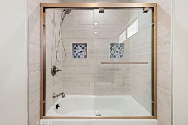 bathroom featuring combined bath / shower with glass door