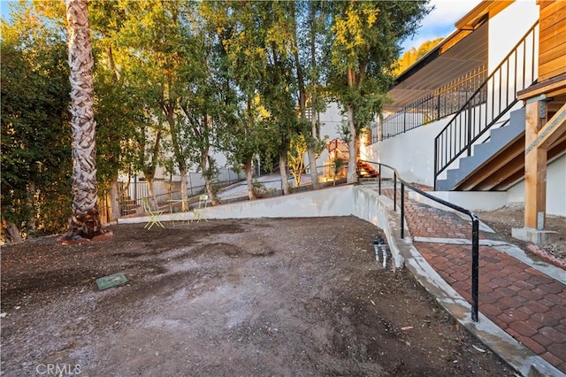 view of yard featuring fence and stairway