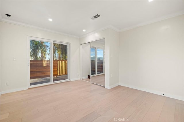 unfurnished room featuring light wood-style floors, a healthy amount of sunlight, visible vents, and ornamental molding