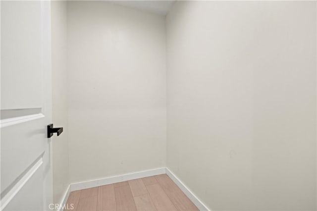 laundry area featuring light wood-type flooring and baseboards