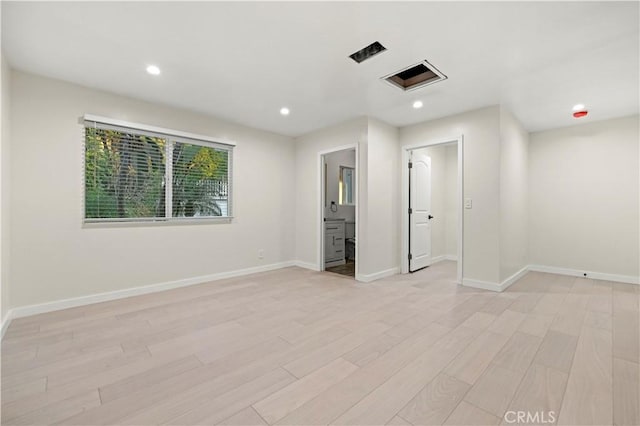 unfurnished bedroom with recessed lighting, light wood-style flooring, and baseboards