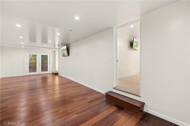 unfurnished living room with baseboards, french doors, wood finished floors, and recessed lighting