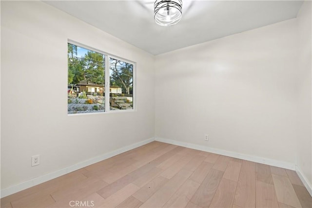 unfurnished room featuring light wood-style flooring and baseboards