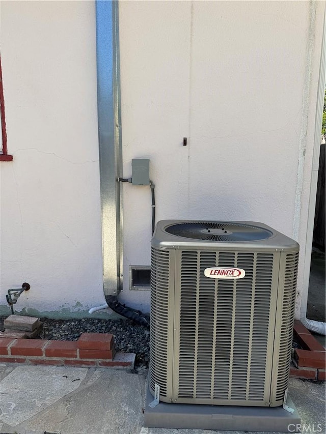 exterior details featuring stucco siding and central air condition unit