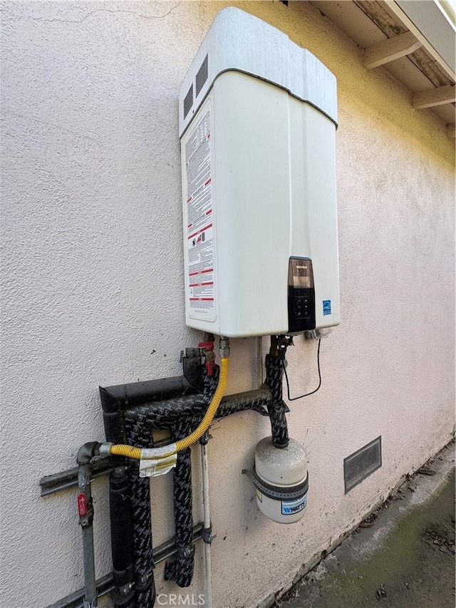 exterior details with tankless water heater and stucco siding