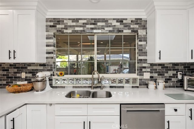 kitchen with stainless steel dishwasher, tasteful backsplash, light countertops, and a sink