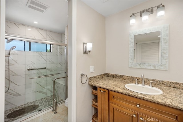 bathroom with toilet, a marble finish shower, visible vents, and vanity