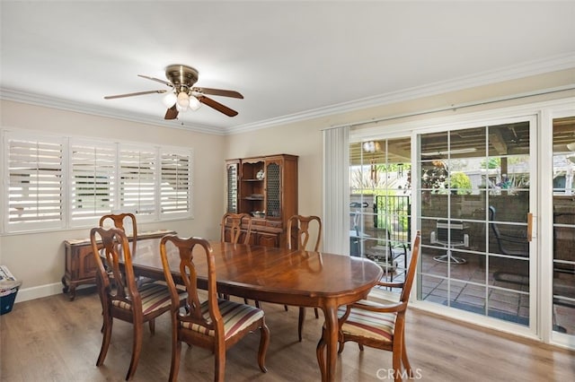 dining space with a ceiling fan, baseboards, crown molding, and wood finished floors