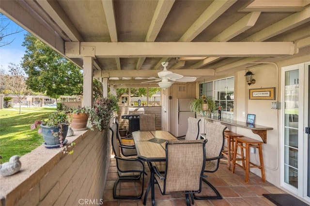 wooden terrace featuring outdoor dry bar, a ceiling fan, and outdoor dining space