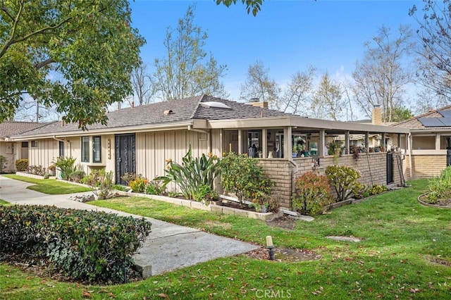 ranch-style home with board and batten siding and a front yard