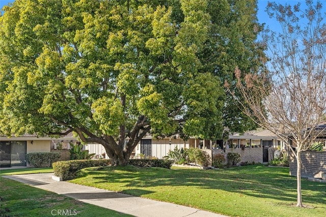 view of front facade featuring a front yard and fence