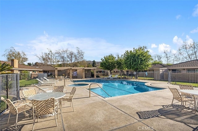 pool featuring a patio, a community hot tub, and fence