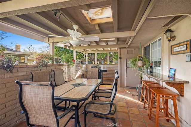 view of patio / terrace featuring a ceiling fan, outdoor dining space, and outdoor dry bar