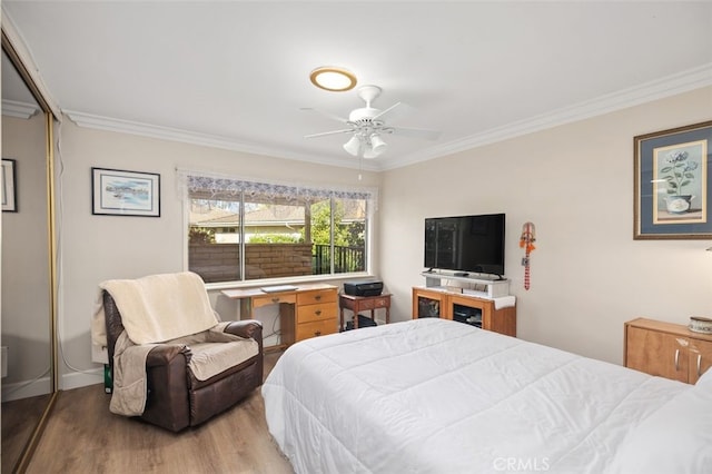 bedroom featuring baseboards, ornamental molding, and wood finished floors