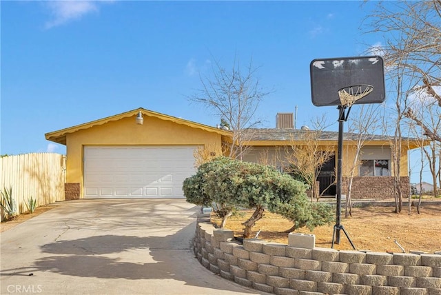 view of front of property featuring an attached garage, brick siding, fence, driveway, and stucco siding