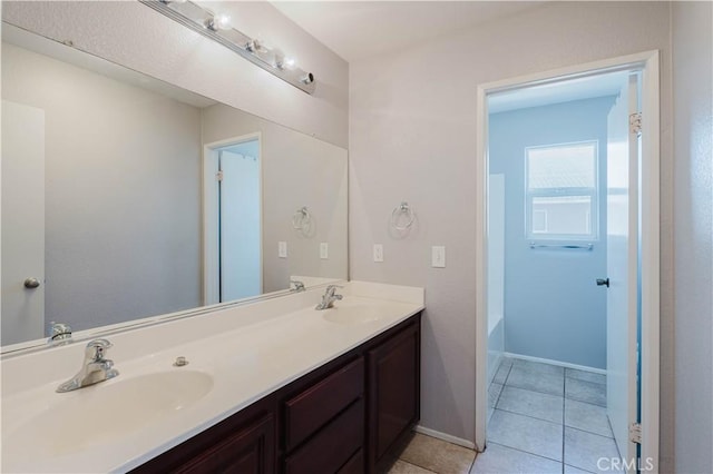 bathroom featuring a tub to relax in, tile patterned flooring, a sink, and double vanity