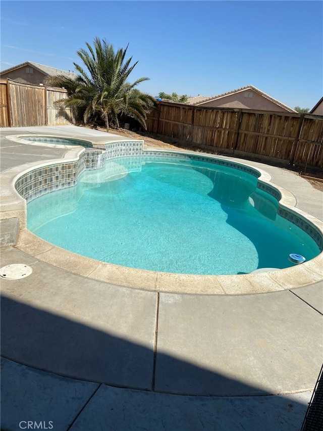 view of pool with a fenced backyard, a fenced in pool, and an in ground hot tub