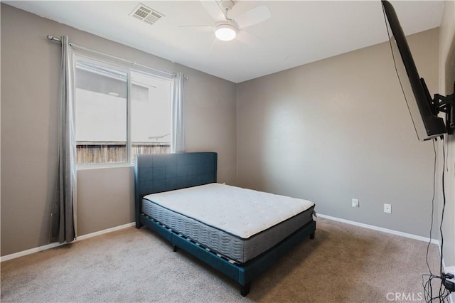 carpeted bedroom with a ceiling fan, visible vents, and baseboards