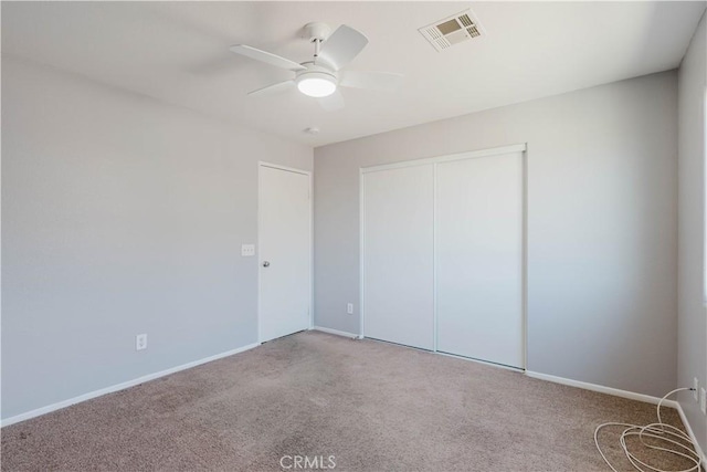 unfurnished bedroom featuring carpet floors, a closet, visible vents, ceiling fan, and baseboards