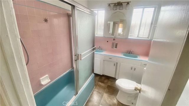 bathroom with toilet, enclosed tub / shower combo, and vanity