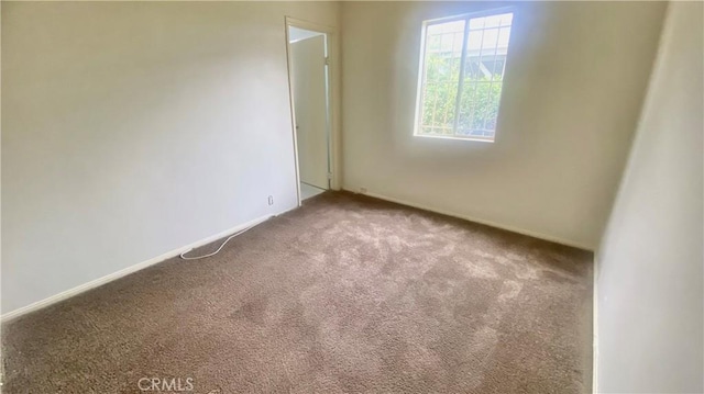 carpeted spare room with baseboards