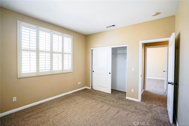 unfurnished bedroom with a closet, baseboards, visible vents, and carpet flooring
