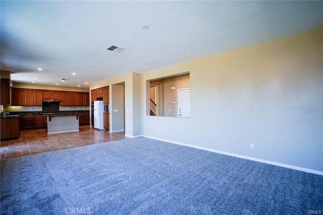 unfurnished living room featuring tile patterned flooring, recessed lighting, visible vents, baseboards, and carpet