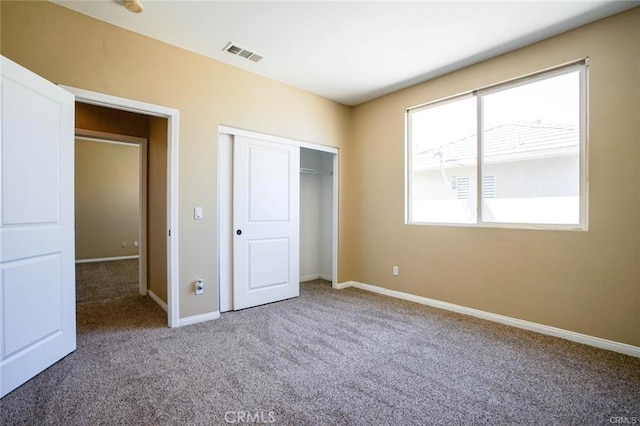 unfurnished bedroom featuring carpet, a closet, visible vents, and baseboards