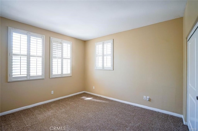 carpeted empty room with baseboards