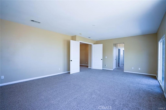 unfurnished room with baseboards, visible vents, and carpet flooring