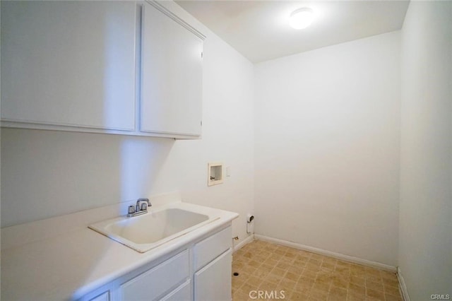 laundry room featuring cabinet space, baseboards, washer hookup, and a sink