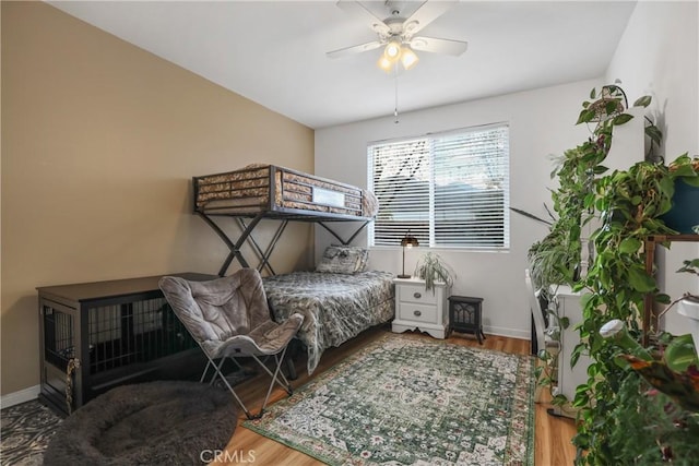 bedroom featuring a ceiling fan, baseboards, and wood finished floors