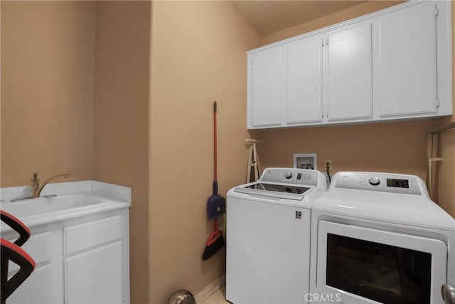 washroom featuring washer and clothes dryer, a sink, and cabinet space