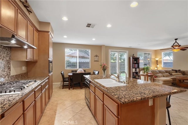 kitchen featuring stainless steel gas cooktop, a center island with sink, recessed lighting, visible vents, and a sink