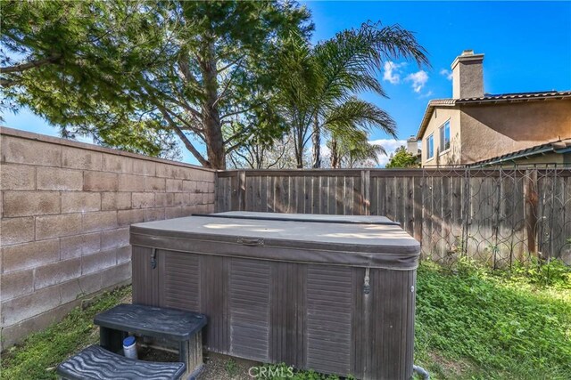 exterior details featuring a fenced backyard and a jacuzzi