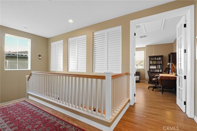 corridor with recessed lighting, wood finished floors, visible vents, baseboards, and attic access