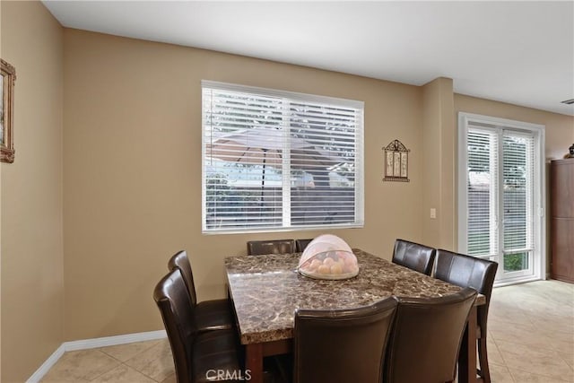 dining room with light tile patterned floors and baseboards