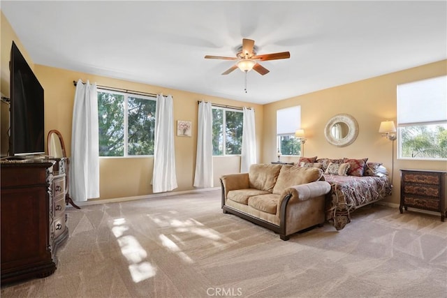 bedroom featuring ceiling fan, baseboards, and light colored carpet