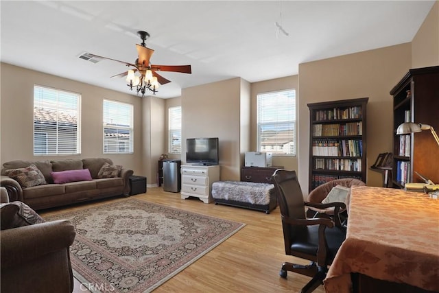 living area with light wood-type flooring, plenty of natural light, and ceiling fan