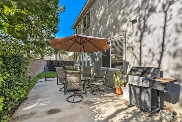 view of patio with outdoor dining space, a fenced backyard, and a grill