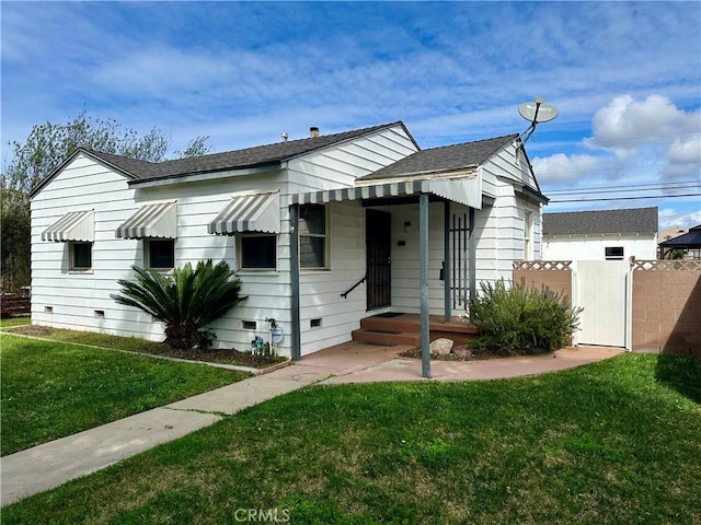 bungalow featuring a shingled roof, a front yard, crawl space, and a gate