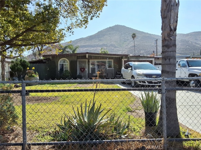 view of front facade featuring a front yard, fence, and a mountain view